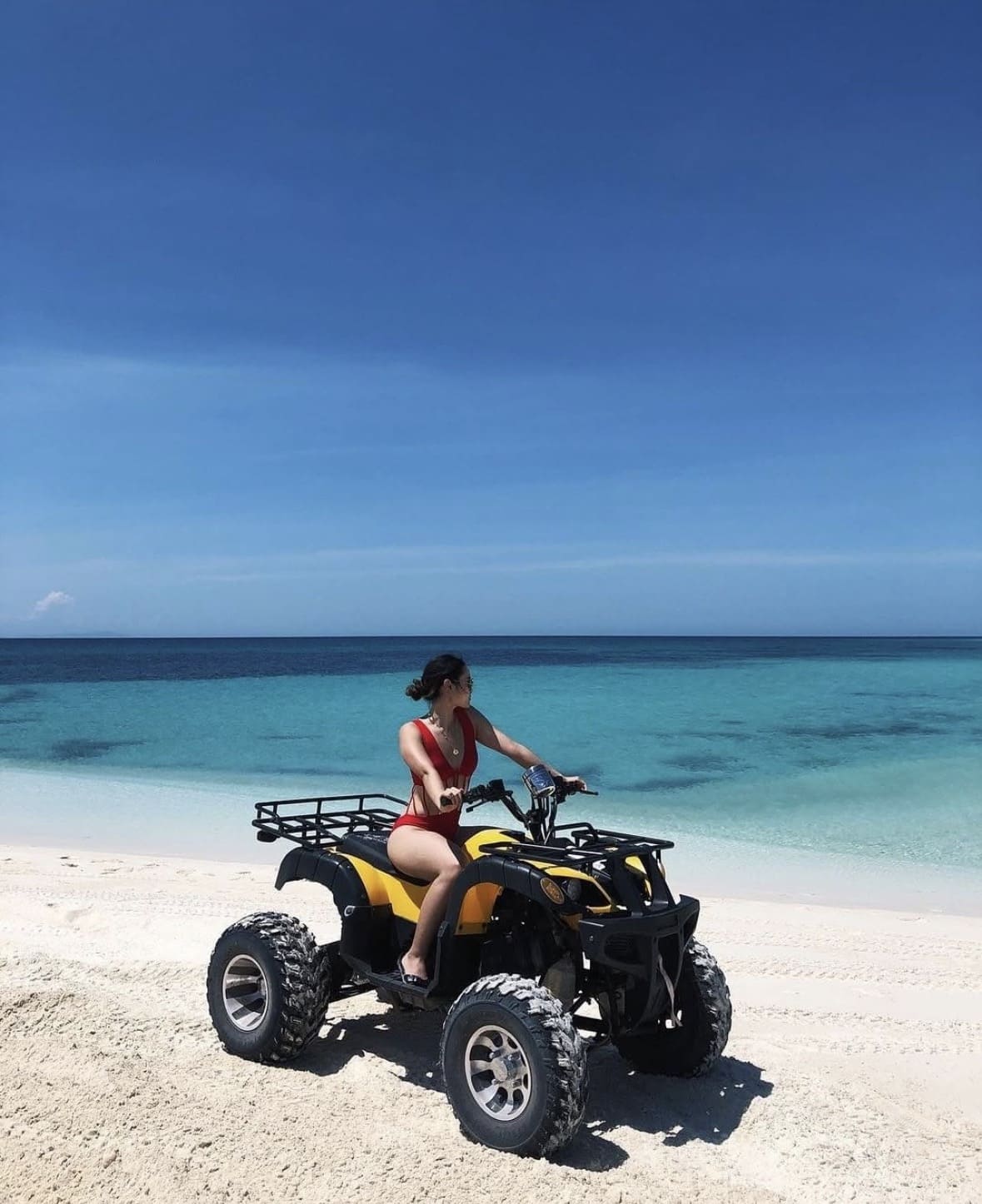 ATV quad bike riding on white sand beach Mantanani Island Sabah